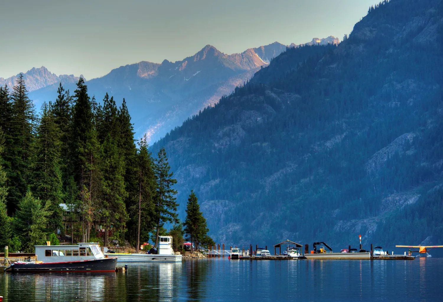 boats on the water with mountains and trees surrounding