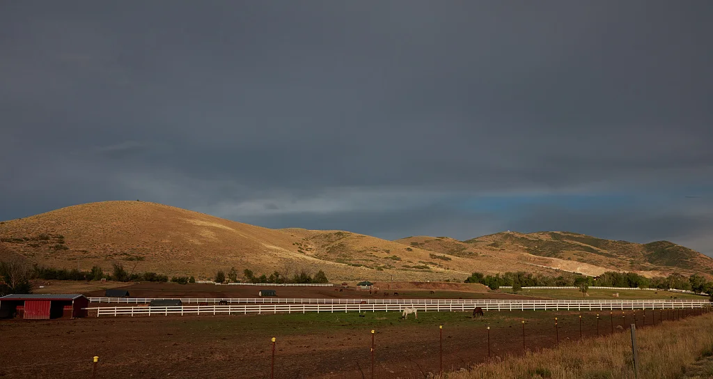 Horses graze beneath low hills near Heber City, 43 miles southeast of Salt Lake City in Wasatch County, Utah